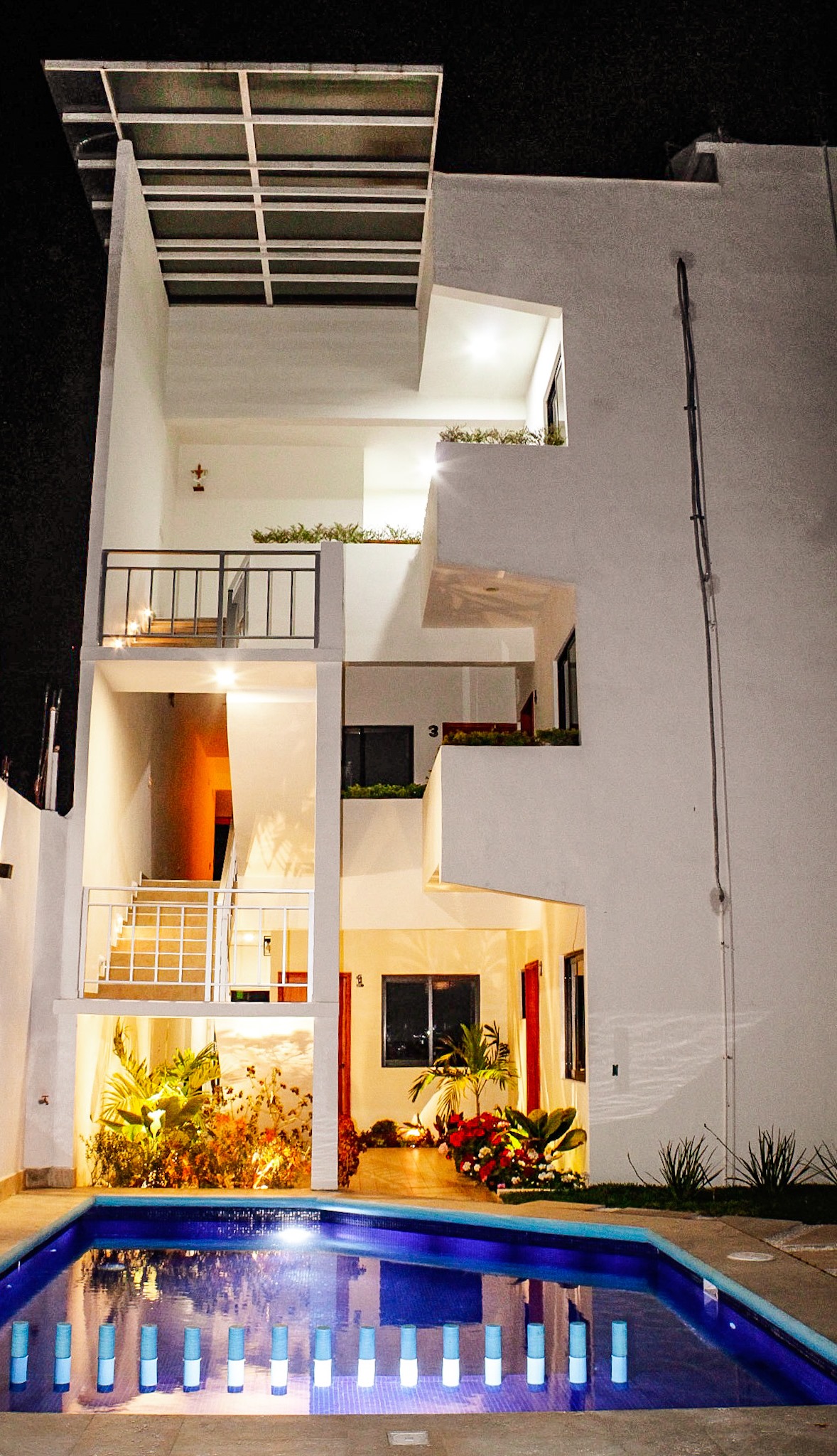 Vista nocturna del hotel y alberca